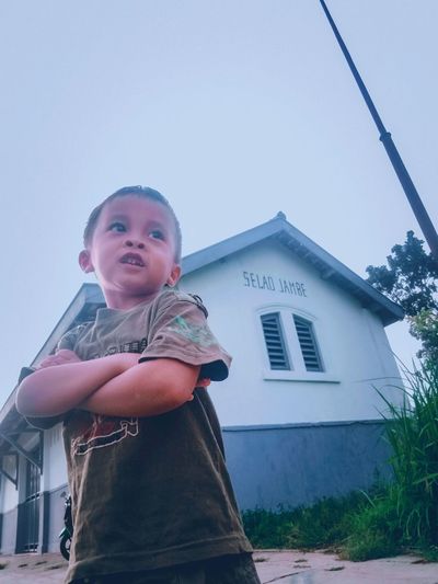 Portrait of cute boy against building