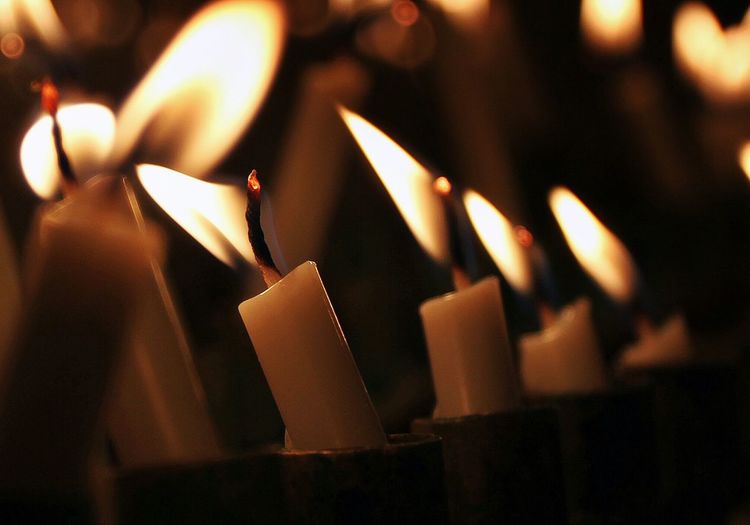 Close-up of illuminated candles in holder