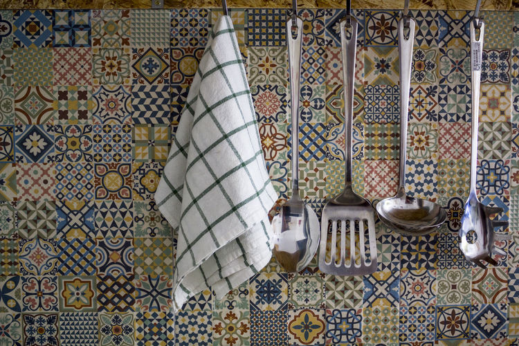 Kitchen utensils and kitchen towel hanging on kitchen wall
