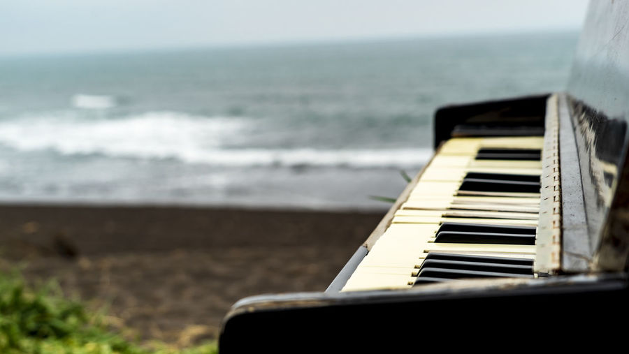 View of piano at beach against sky