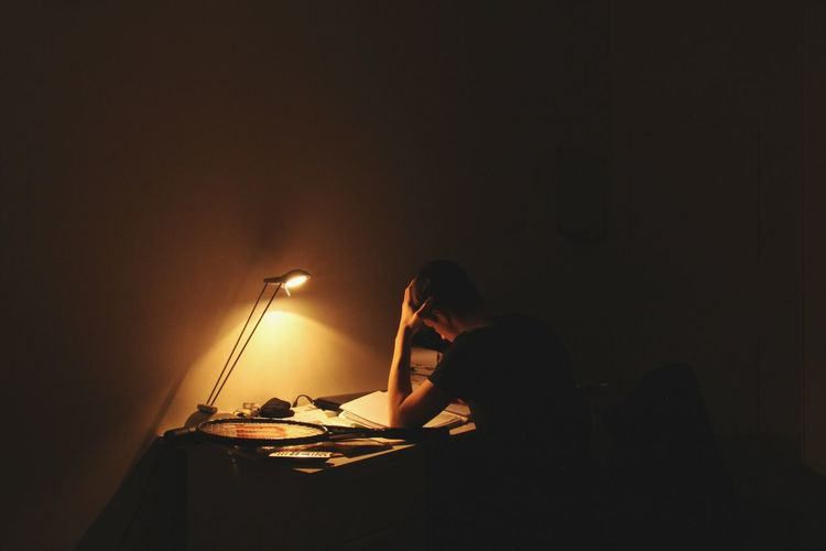 Teenager studying in dark at home