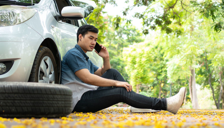 Full length of young man sitting in car