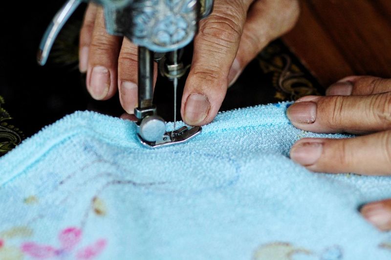 Close-up of woman sewing towel