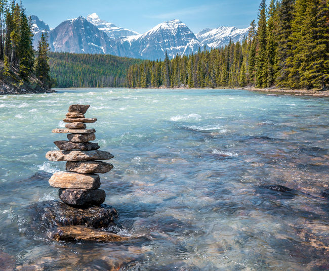 Stack of rocks by lake during winter