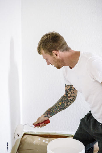 Young man painting wall