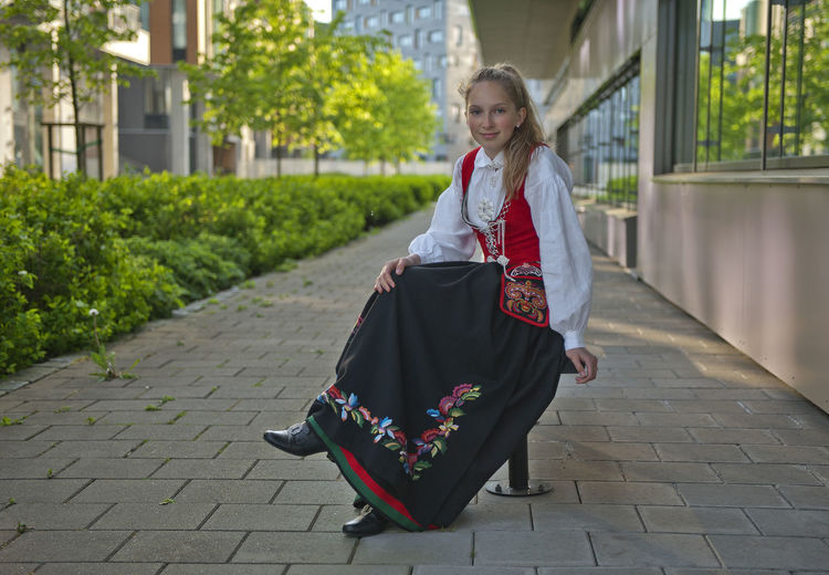 Portrait of smiling teenager girl on footpath