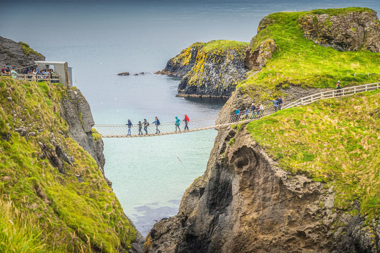 Closeup on people on the carrick a rede rope bridge, northern ireland