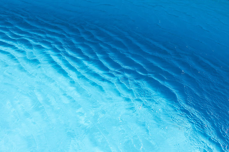 View of surface of turquoise water in swimming pool, sea or ocean, summer background. gradient.