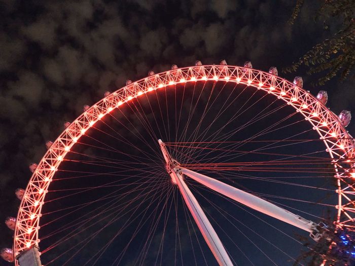Low angle view of illuminated millennium wheel against sky at night