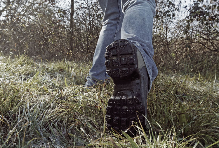 Low section of man standing on field