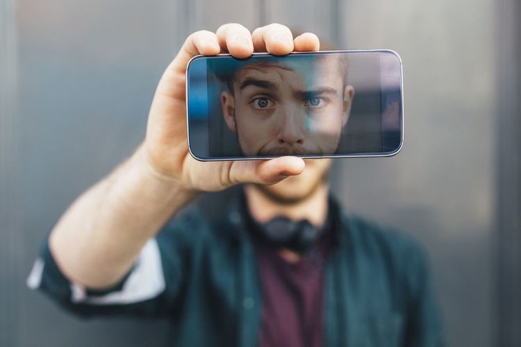 Portrait of man holding mobile phone