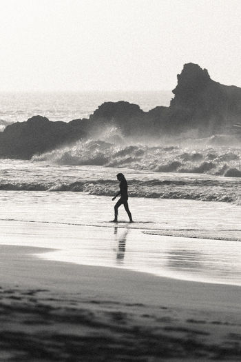 Silhouette woman walking at beach