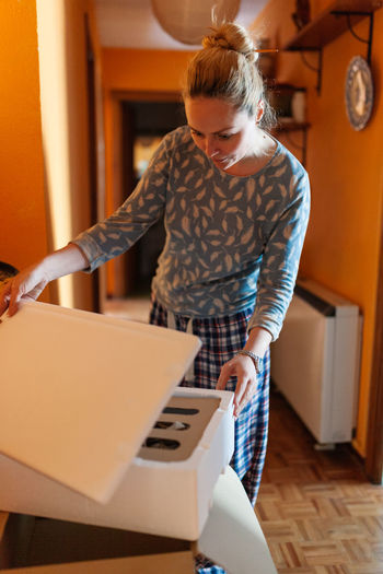 Woman opening and checking deliver box with precooked food
