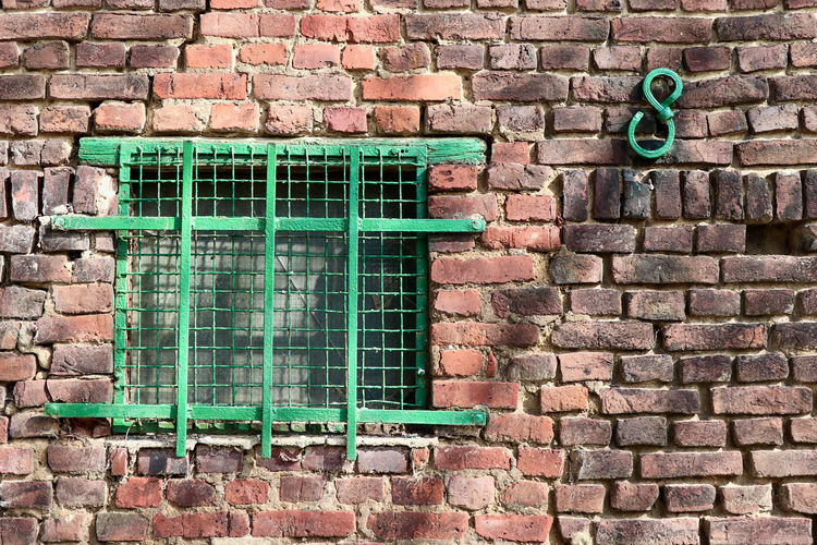 Full frame shot of red brick wall with   old green window