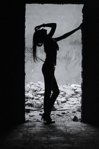 Rear view of silhouette woman standing against wall