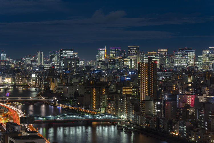 Aerial night view of the sumida river bridges and higways light-up with the skyscrapers of tokyo.