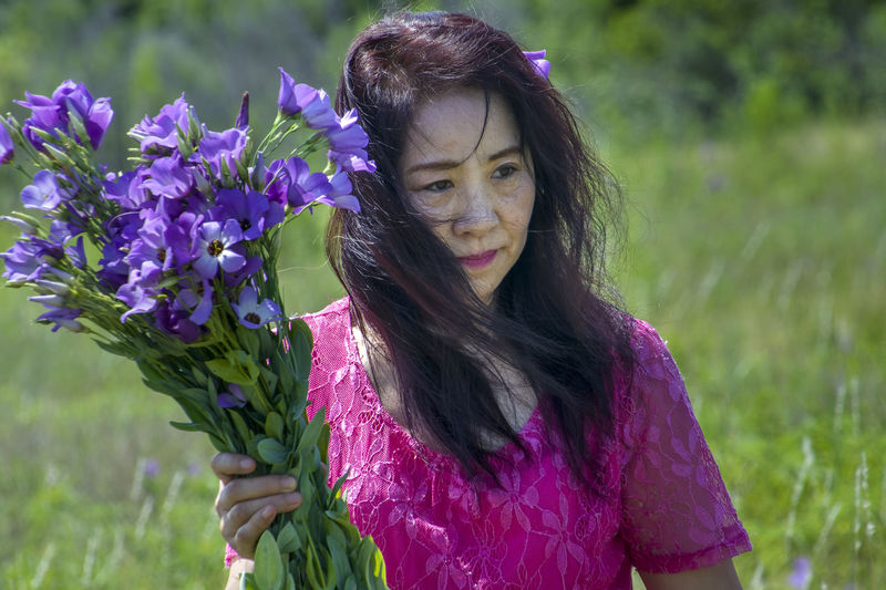 Portrait of woman on purple flowering plant