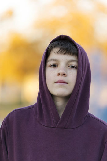 Close-up portrait of boy in hooded shirt