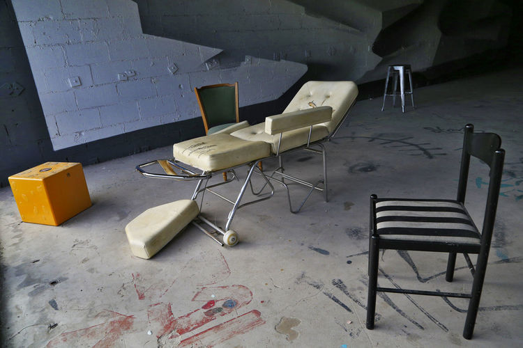 High angle view of empty chairs and table against wall in building