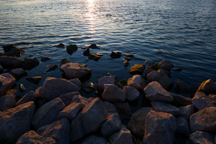 Rocks in sea at sunset