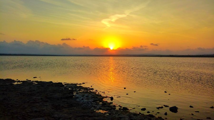 Scenic view of sea against orange sky