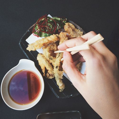 Close-up of person hand eating deep fried shrimp