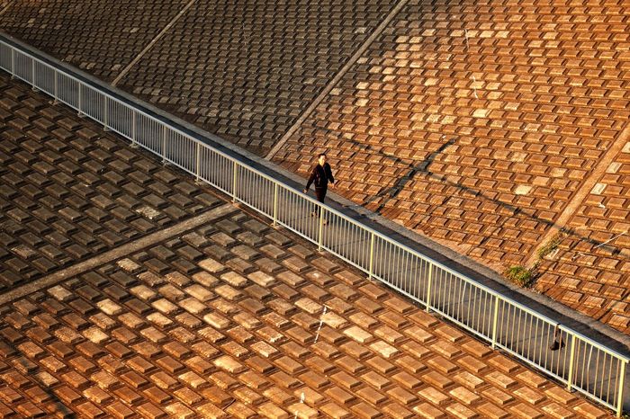 High angle view of man walking on footpath by roof