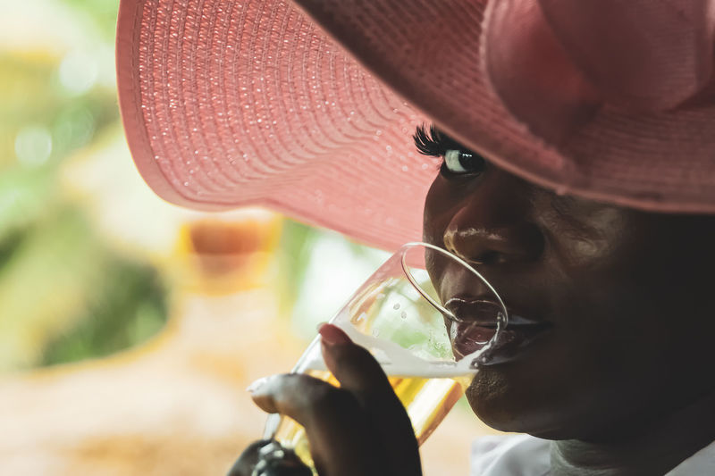 Side view of woman drinking straw hat