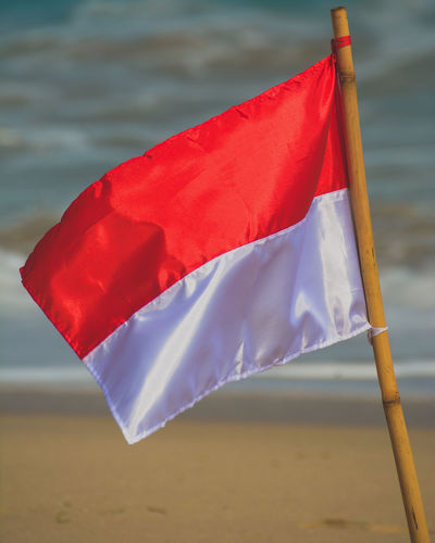 Close-up of flag waving at beach
