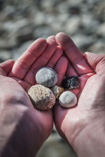 Cropped hand of person holding pebble stones