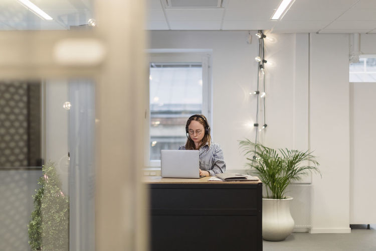 Woman wearing headset working in office