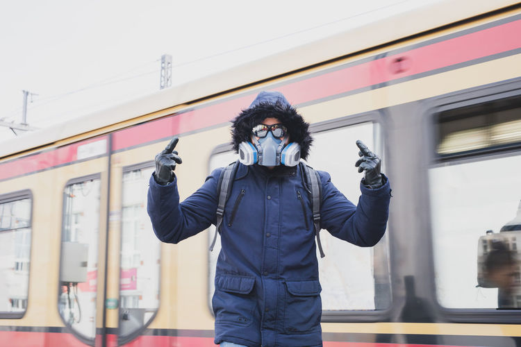 Man photographing with mask on standing in winter