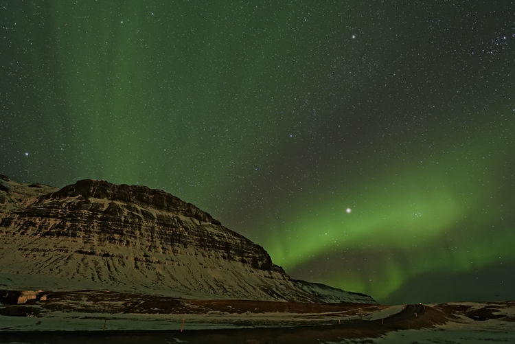 Low angle view of aurora borealis at night during winter