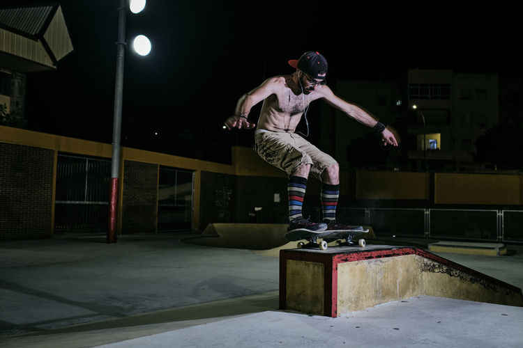 Young white man jumping on his skateboard