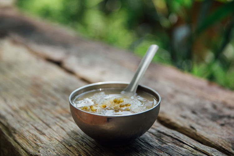 Close-up of bean soup with spoon in bowl on wooden table