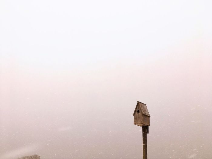 Bird house against cloud sky