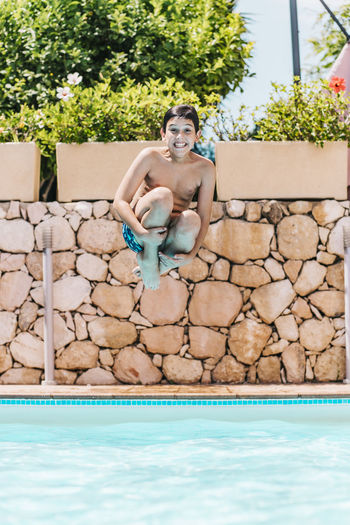 Portrait of boy jumping in swimming pool