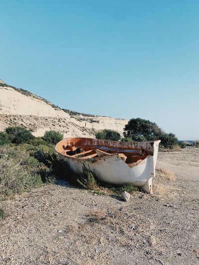 Abandoned boat on beach against clear sky