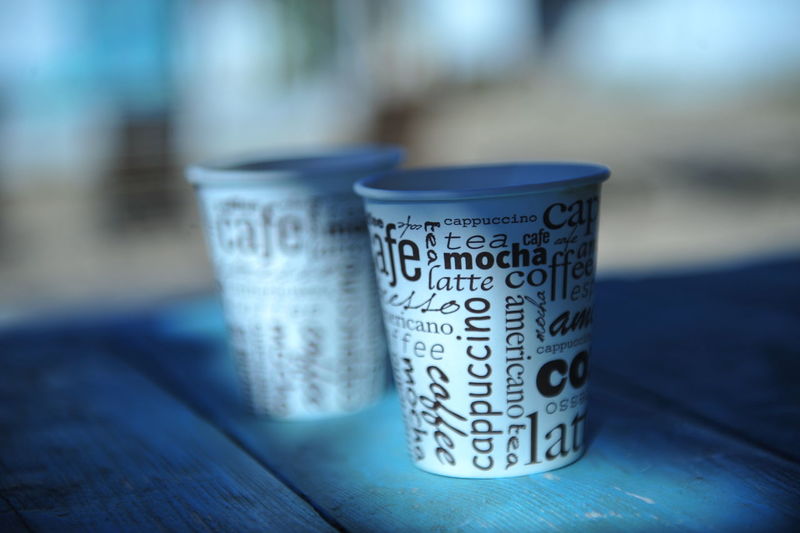 Close-up of text on disposable cups at table