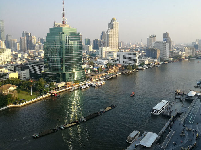 River amidst buildings in city against sky