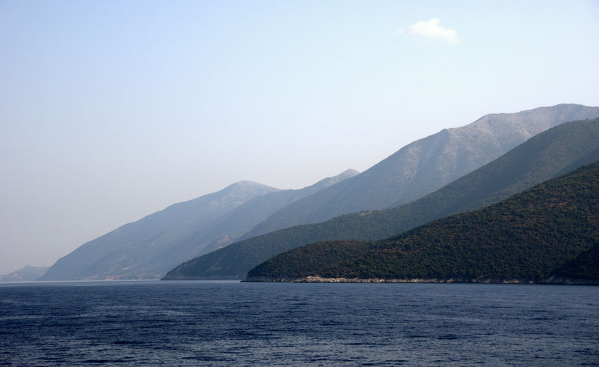 Scenic view of sea and mountains against sky