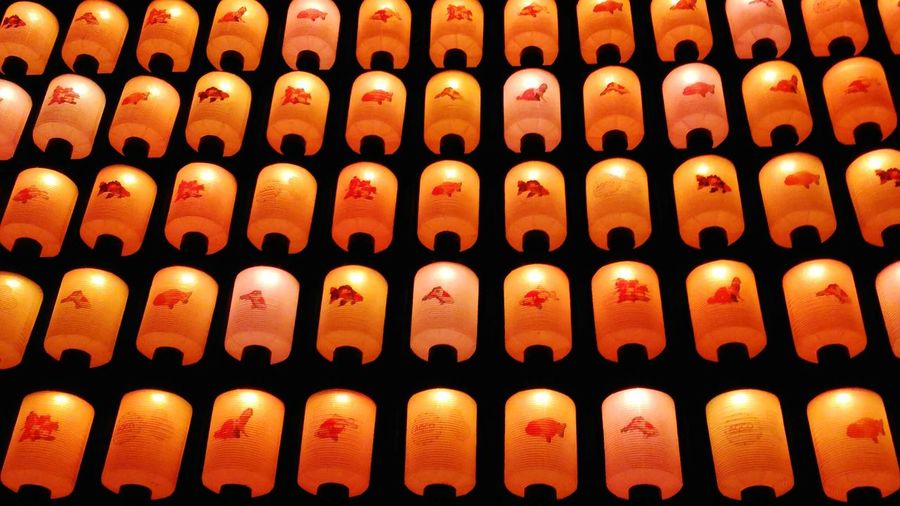 Full frame shot of orange illuminated japanese lanterns at night