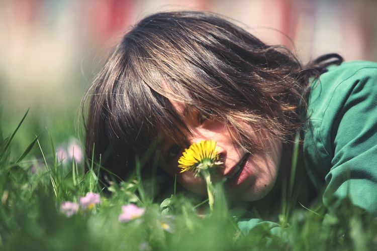 Close-up of woman with flowers in grass