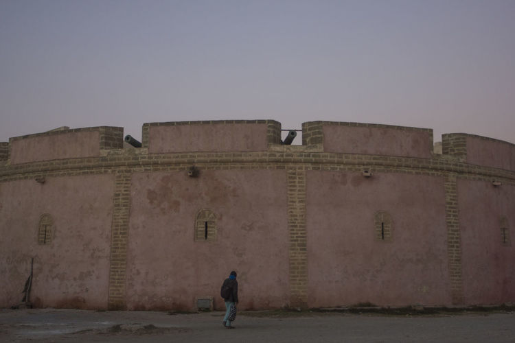 Man walking on fort against clear sky