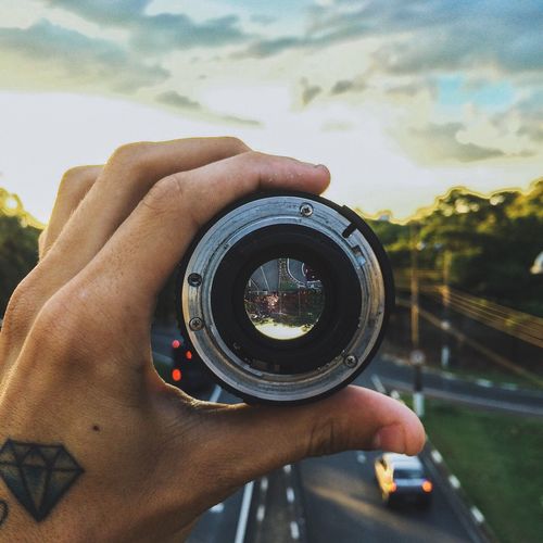Cropped image of hand holding camera lens
