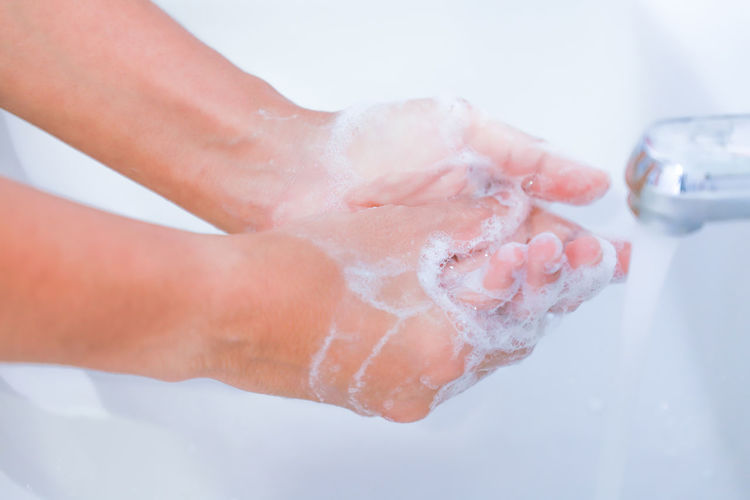 Close-up of woman hand with ice cream in water