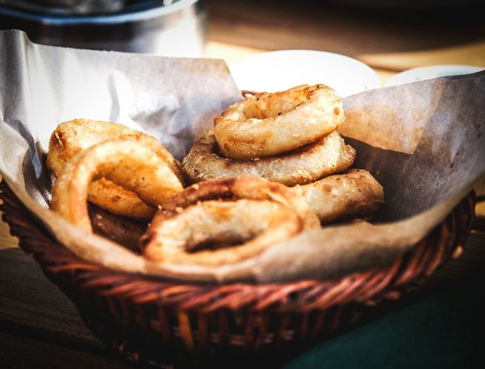 Close-up of onion rings in basket on table