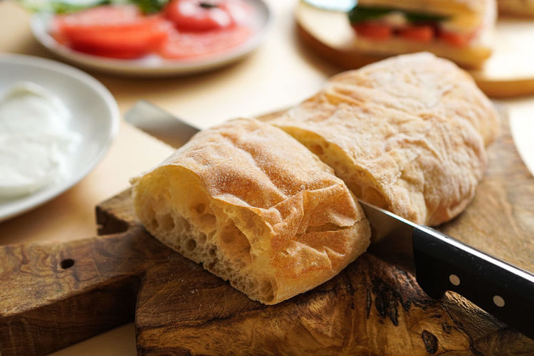Cutting bread at the table to make sandwiches panini