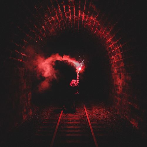 Woman with flaming torch in tunnel