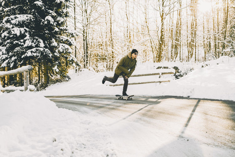 Full length of man skateboarding in snow